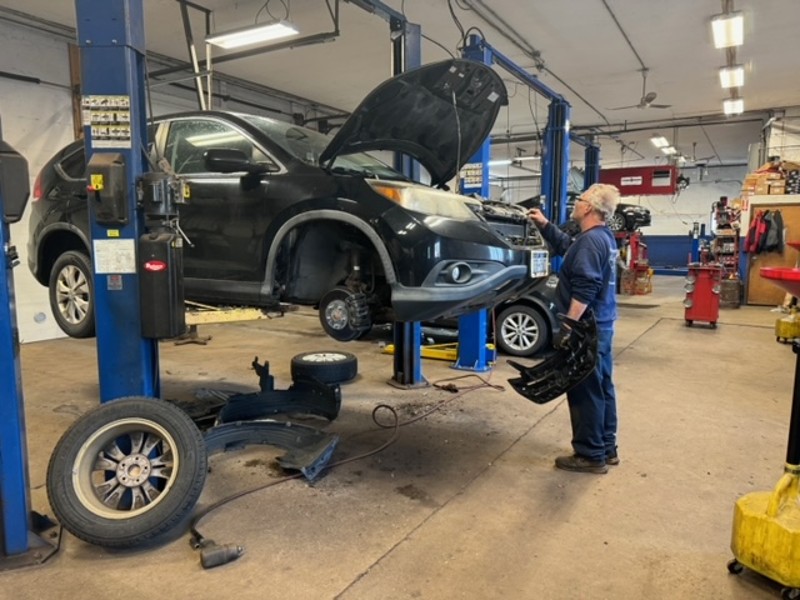 auto shop near liverpool ny image of first automotive technician working on a car with the hood open