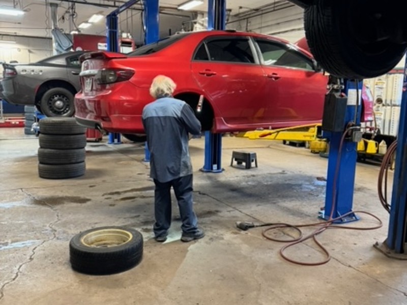 brakes near liverpool ny image of first automotive worker working on brakes of red car