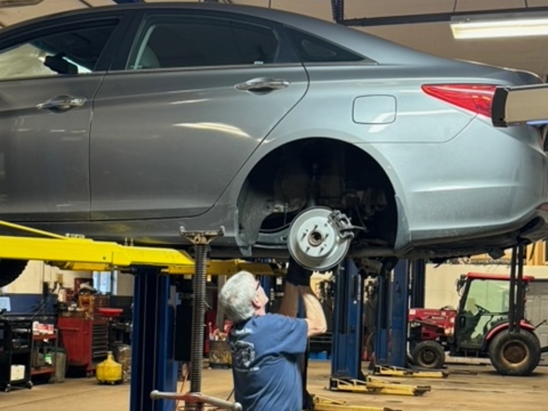 brake replacement near liverpool ny image of first automotive worker replacing brakes on car